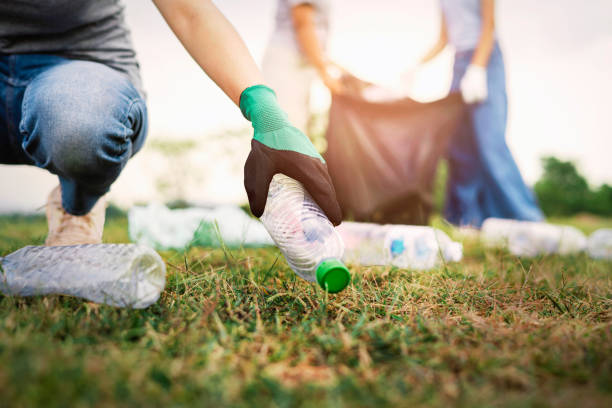 istock woman hand picking up garbage plastic bottle for cleaning at park 1394781384