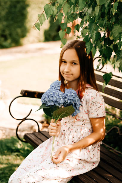 istock A child with a bouquet of flowers in his hands. Blue hydrangea. 1394783063