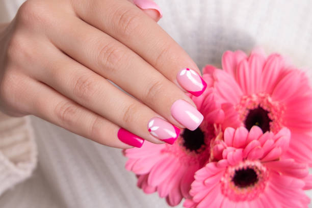istock Female hands with pink manicure, flowers design 1394784164