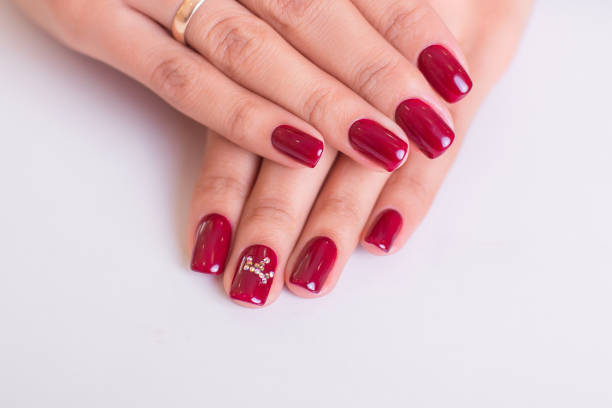 Beautiful female hands with luxury manicure nails, red gel polish, on white background