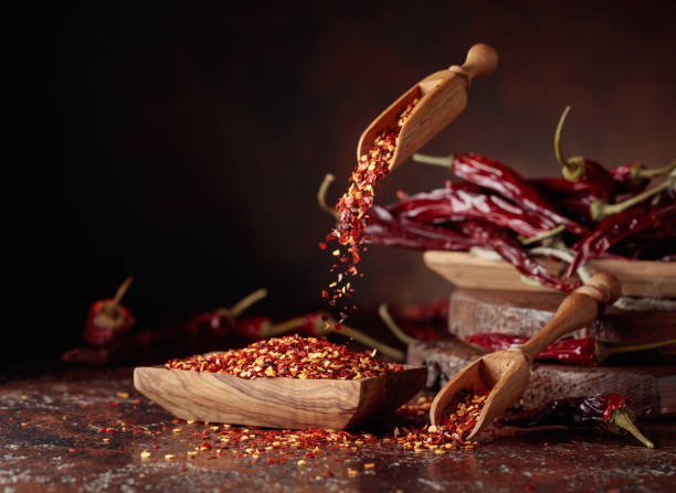 istock Chilli flakes are poured into a wooden dish. 1394784532