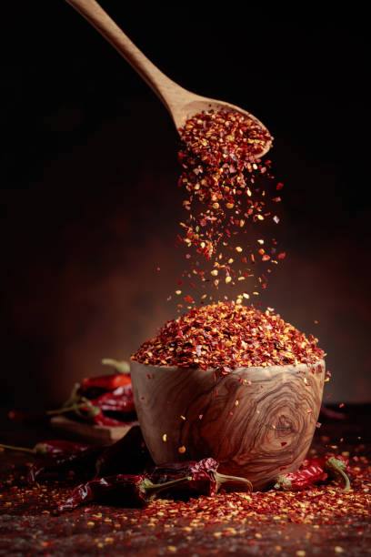 istock Chilli flakes are poured into a wooden dish. 1394784535