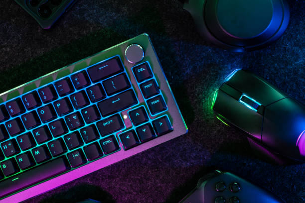 gamer work space concept, top view a gaming gear, mouse, keyboard, joystick, headset, mobile joystick, in ear headphone and mouse pad on table background.