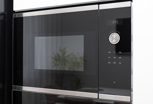 dark glass microwave oven built in with touch control and time display. modern kitchen furniture