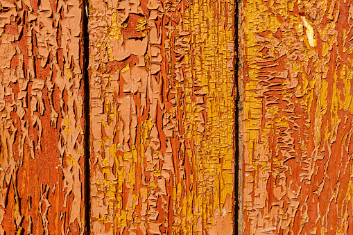 old red wooden boards with cracked and peeling paint. Background and texture