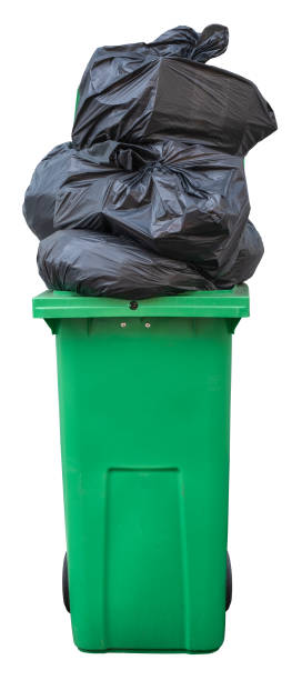Overflowing Green Trash Bin A Green Wheelie Bin, Overflowing With Bin Bags (Trash), Isolated On A White Background overflowing dumpster stock pictures, royalty-free photos & images