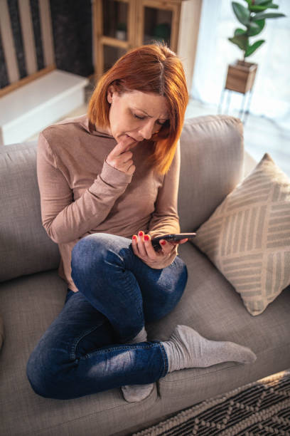 istock depressed woman at home using smartphone and laptop 1394794681