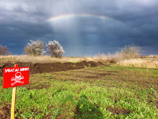 Mine field in Ukraine with rainbow and dramatic sky.