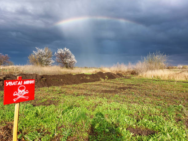 Mine field in Ukraine with rainbow and dramatic sky. stock photo