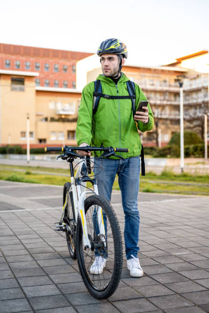 istock Delivery man looking for address, young rider using mobile application and city map for searching the customer, ecologic fast courier new business 1394798247