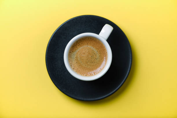 istock Cup of coffee on yellow  background. Top view. Close up. Copy space. 1394798305