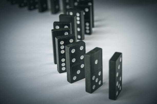 istock Black dominoes chain on table background 1394800720