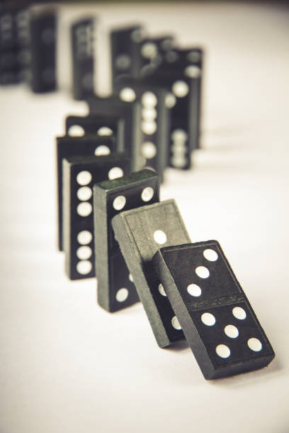 istock Black dominoes chain on white table background 1394800725