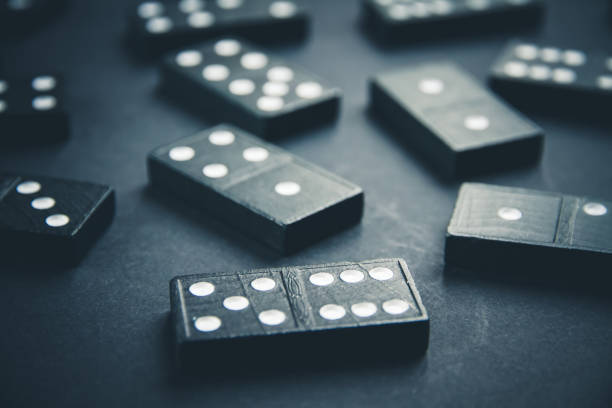 istock Black dominoes on dark table background 1394800735