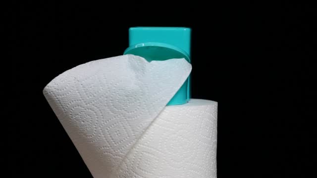 footage of miniature toilet paper dark background