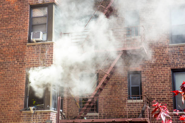 istock An old apartment is on fire with smoke coming out from the window. 1394804304