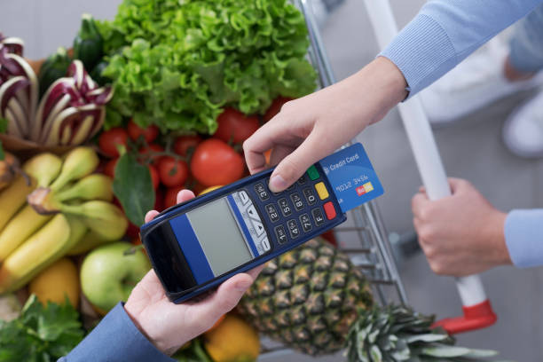 istock Woman paying for groceries using a credit card 1394804441