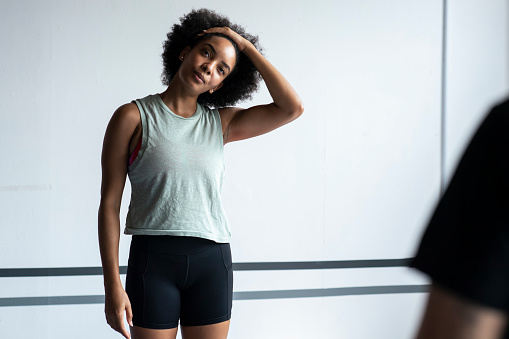 African American woman smiling while stretching during a fitness class