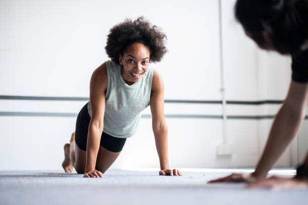 istock Smiling African American woman doing push-up during exercise class 1394806737