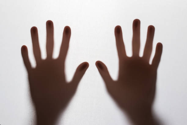Shadow hands of the woman behind the white curtain