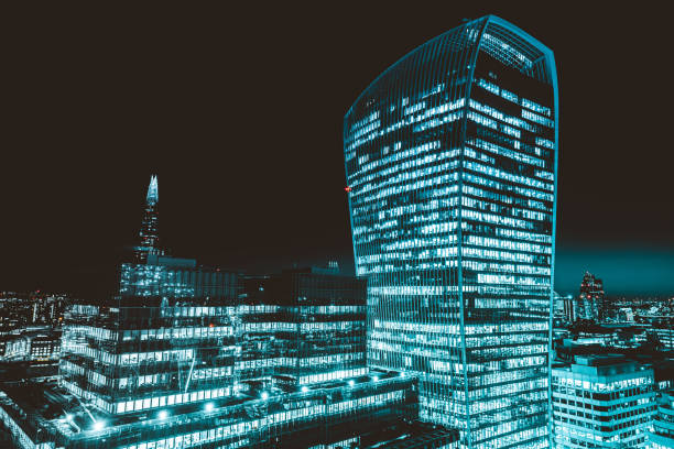 modernes glasgebäude hoch über der brüsseler skyline bei nacht mit beleuchteten büros - fenchurch street stock-fotos und bilder