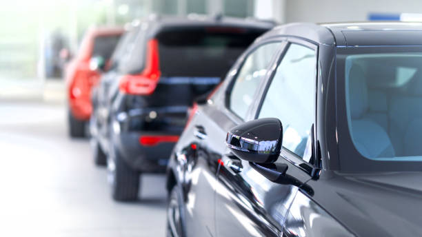 New cars at dealer showroom New cars at dealer showroom. Blurred background. Focus is on the right exterior mirror empty dealership interior stock pictures, royalty-free photos & images