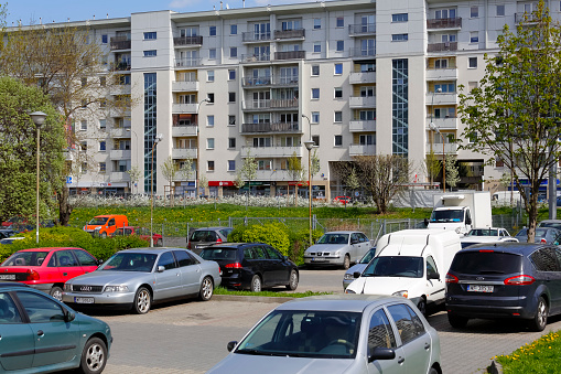Warsaw, Poland - April 30, 2022: View of several various cars that have been parked in a small parking lot next to apartment buildings. It is a car park in the Goclaw estate, Praga Poludnie district.