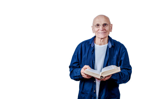 Mature academic wearing eyeglasses and blue shirt holding open book isolated on white background