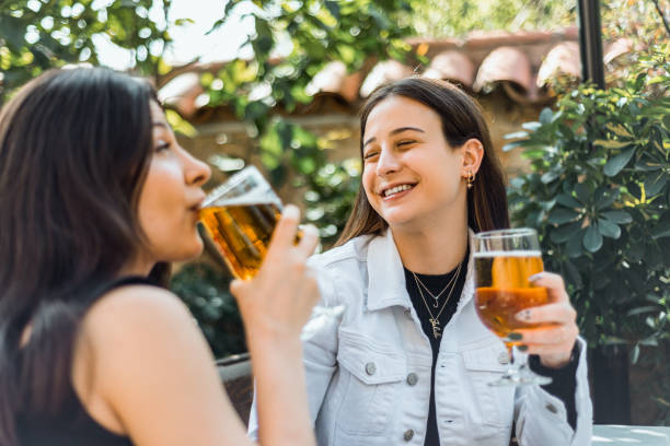 istock Two young woman drinking beer at the bar 1394811420