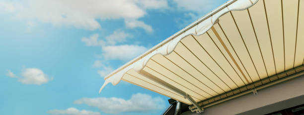 istock retractable awning installed on wall over house window against blue sky. banner with copy space 1394811706