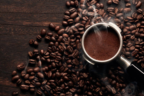 Coffee, beautiful cup of coffee on a heap of coffee beans in a straw sieve, abstract background, selective focus.