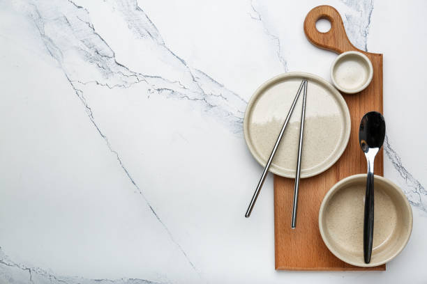 istock empty plates of different sizes on a cutting board with chinese chopsticks on a white background 1394815406