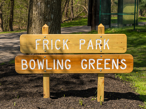 The Frick Park Bowling Greens sign in Frick Park, a city owned park in Pittsburgh, Pennsylvania, USA on a sunny spring day