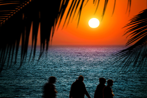 A couple on beach looking at sunset