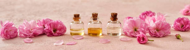 istock Panoramic header with bottles of essential oil with kwanzan cherry blossoms in spring 1394823768