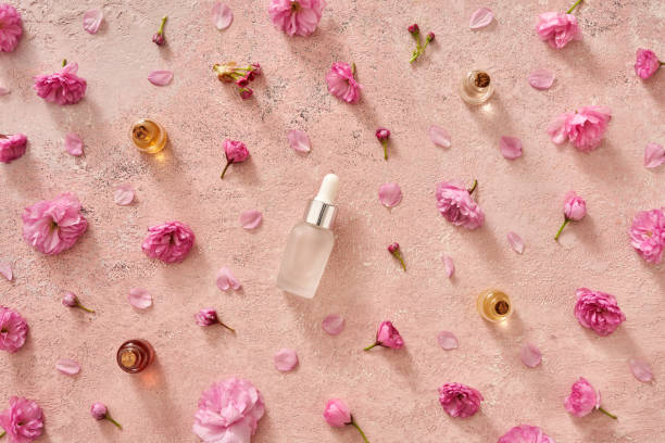 istock Pink background with essential oil bottles with kwanzan cherry blossoms 1394823778