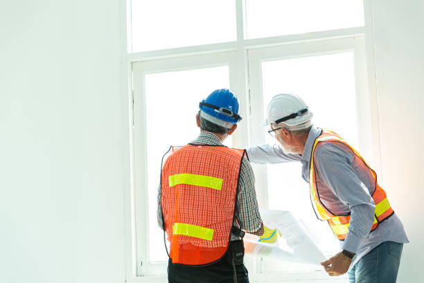 istock Two expertise engineers are having discussion about the buildings project at construction site.  Engineering at the workplace on the white background, with effect filter. Houses and buildings concept. 1394824104