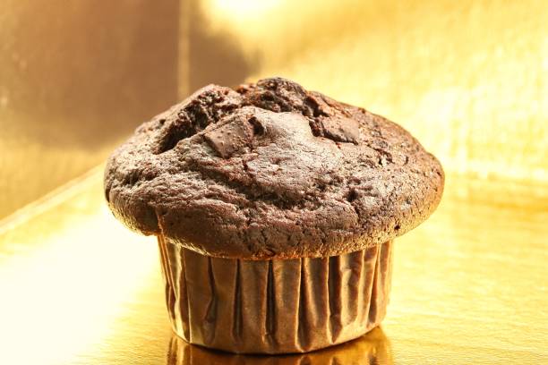 Chocolate muffin ,close-up, gold colored background