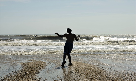 A Young Boy Dancing Joyously on the Beach
