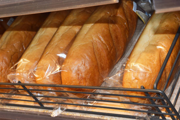 밀 신선한 빵 덩어리가 든 비닐 봉지가 상점 카운터에 놓여 있습니다. - cereal box food carbohydrate 뉴스 사진 이미지