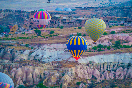 Set of colorful balloons flying over Goreme city in Cappadocia, during sunset on a clear summer day, copy space
