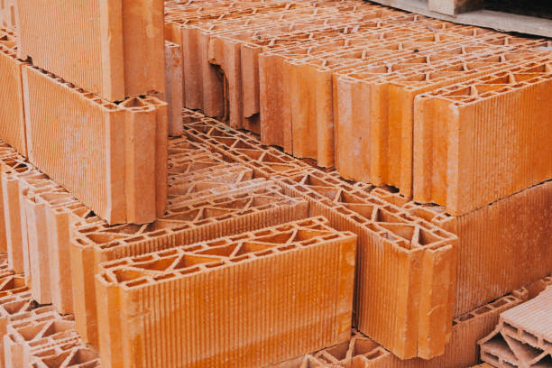 istock Red perforated bricks with thin-walled on wooden pallets in an open-air warehouse ready for sale. 1394839267
