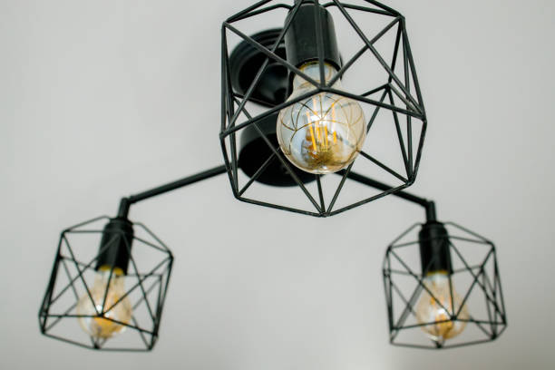 istock Geometric lamp hangs on a white ceiling. Modern, minimalist lamp that successfully complements the interior in loft style 1394841173