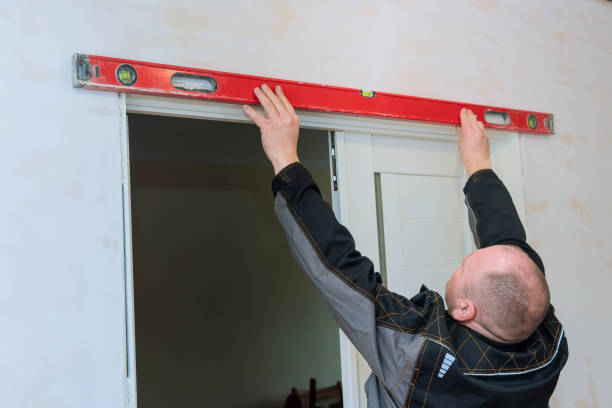 istock Carpenter at interior wood door installation working with level 1394841466