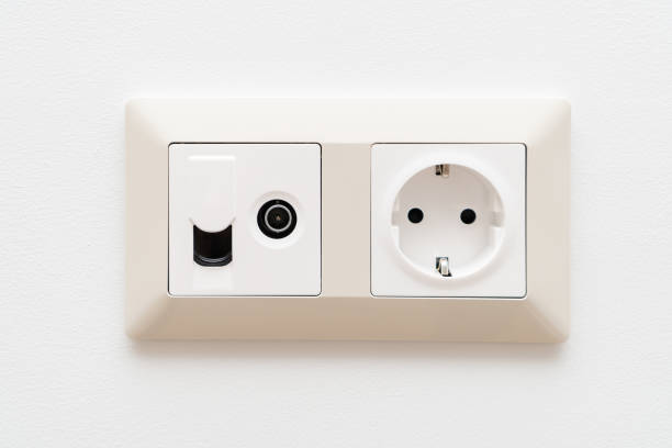 istock Sockets on white wall. Multifunction outlet with internet connection, tv and electric socket plug with grounding. 1394844099