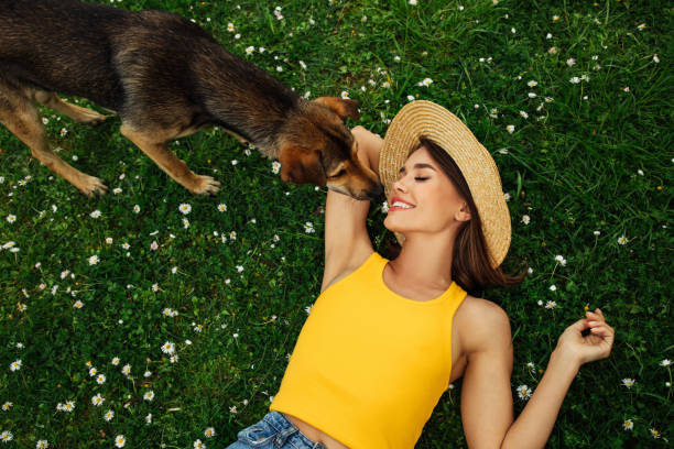 istock Smiling young woman lying on grass 1394845698