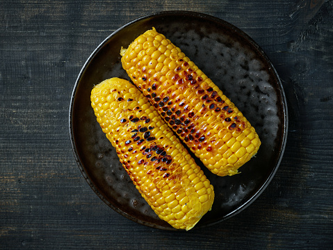 grilled corn on black plate, top view