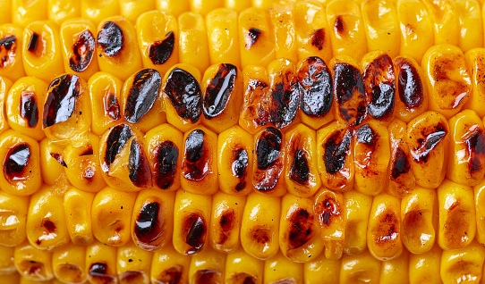 grilled sweet corn macro background, top view