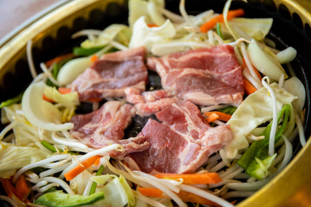 istock Thin sliced beef with vegetables on a hot plate cooking 1394847071