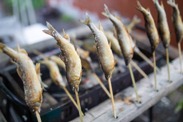 A common sight at Japanese festivals in the countryside. Freshwater fish on sticks grilled over hot coals.